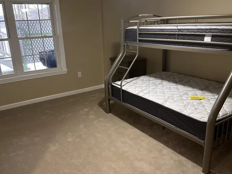 Carpeted bedroom with ceiling fan and large window finished by Dom's Workshop