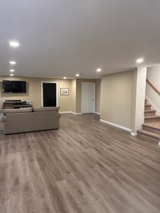 Open living space with recessed lighting and plank flooring finished by Dom's Workshop